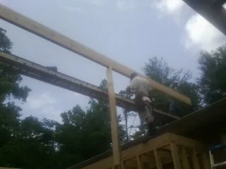 Carpenter setting a ridge beam over a new addition frame — Ice Dam Removal by Roofing Brothers in Pierceton