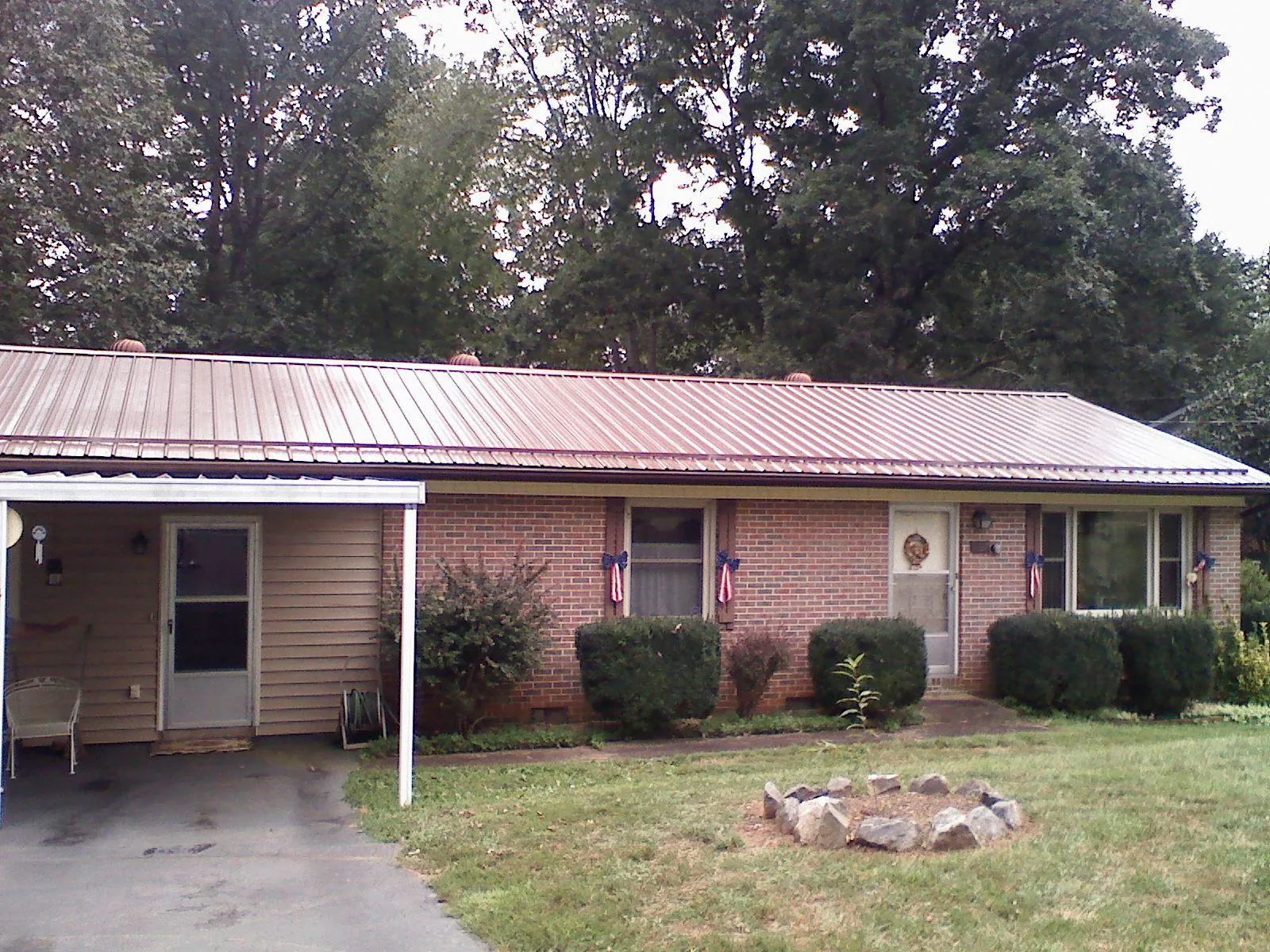 Bronze metal roof and carport on a brick ranch home — Roof Repair work by our crew in Pierceton